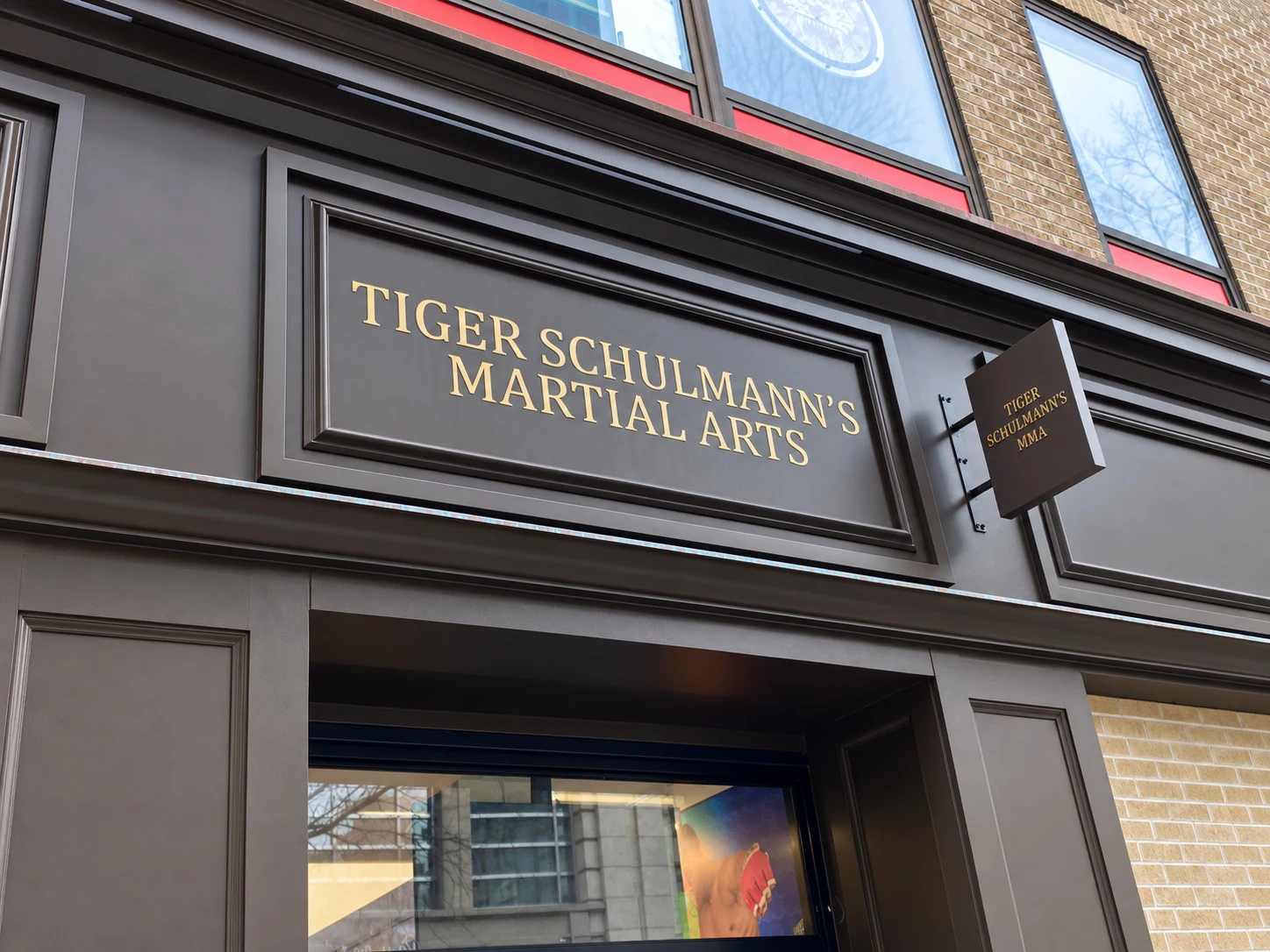688 Sixth Avenue: Dark paneled storefront detail with gold martial arts lettering and a projecting sign