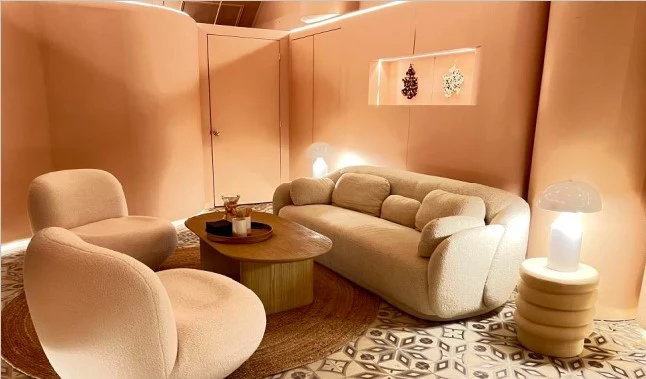Ansa Coffee: Cream sofa and rounded lounge chairs beside illuminated wall niches