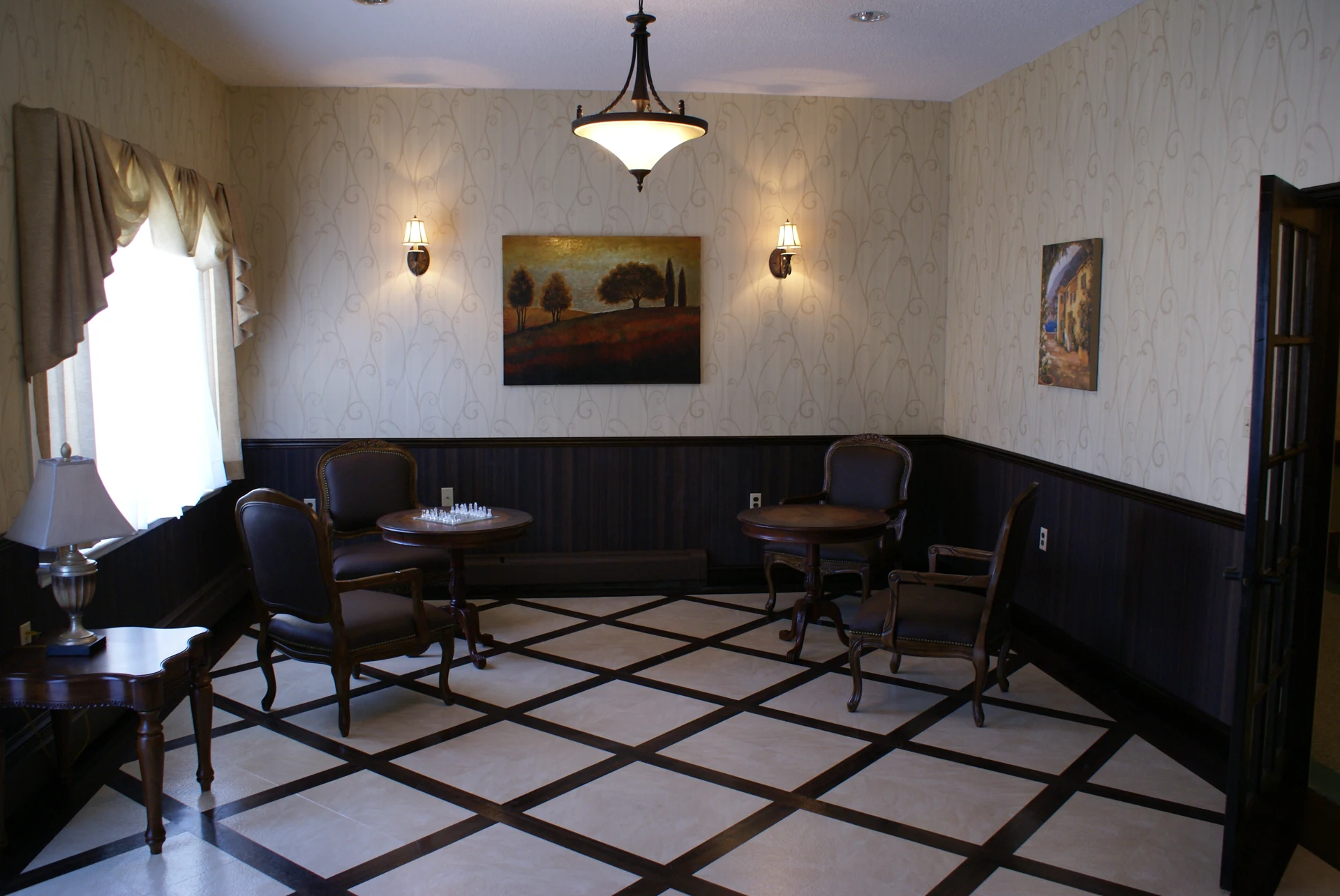 Applegarth: Sitting area with round tables, upholstered chairs, and geometric flooring