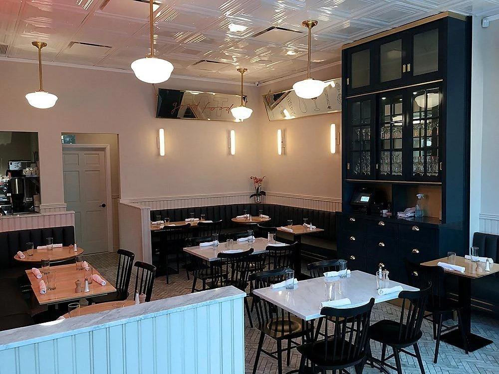 Kirsh Restaurant & Bakery: Dining room with black banquettes, pendant lights and a decorative paneled ceiling