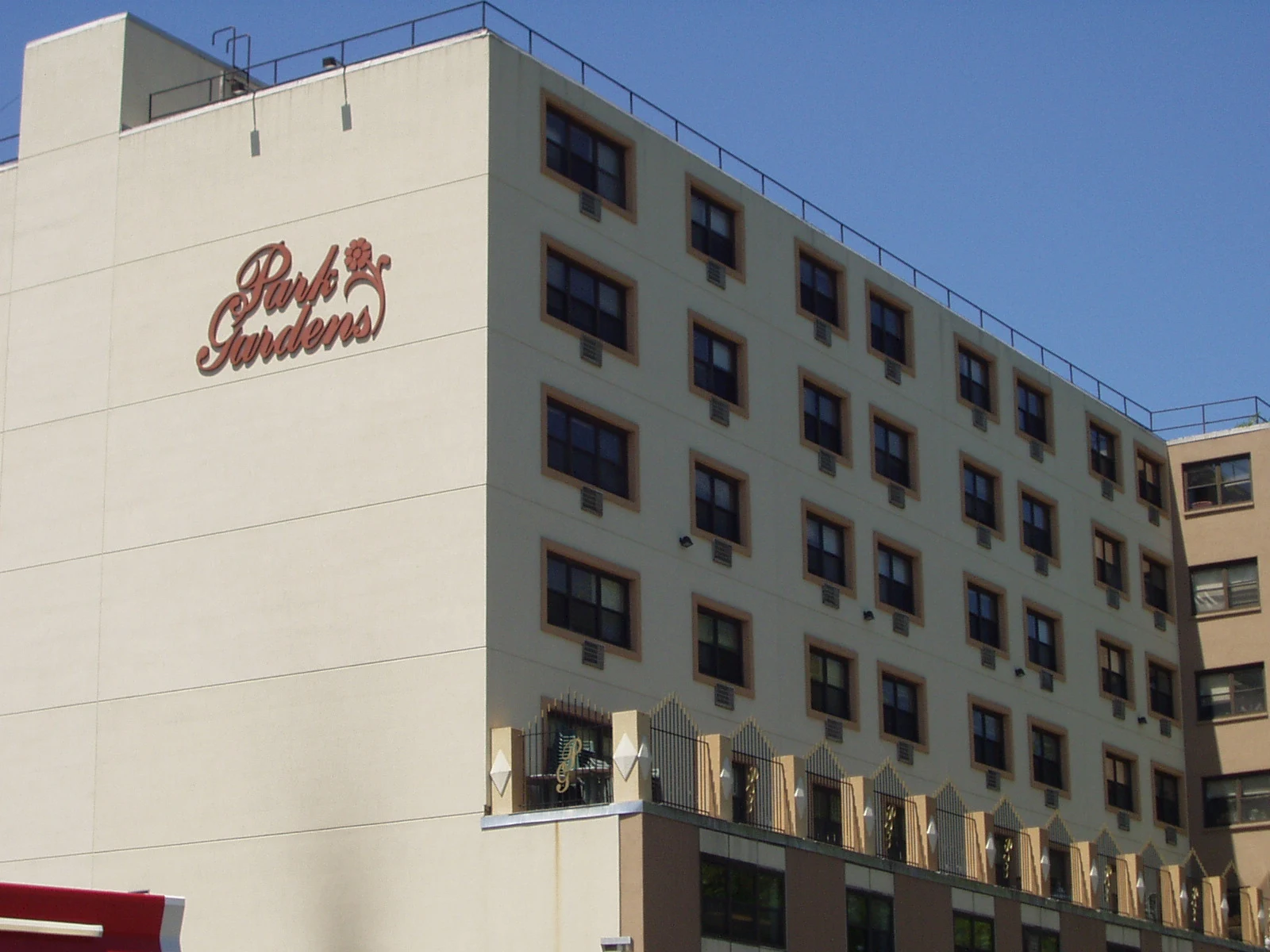 Park Gardens: Multi-story facade with building signage, rows of windows, and terrace railings