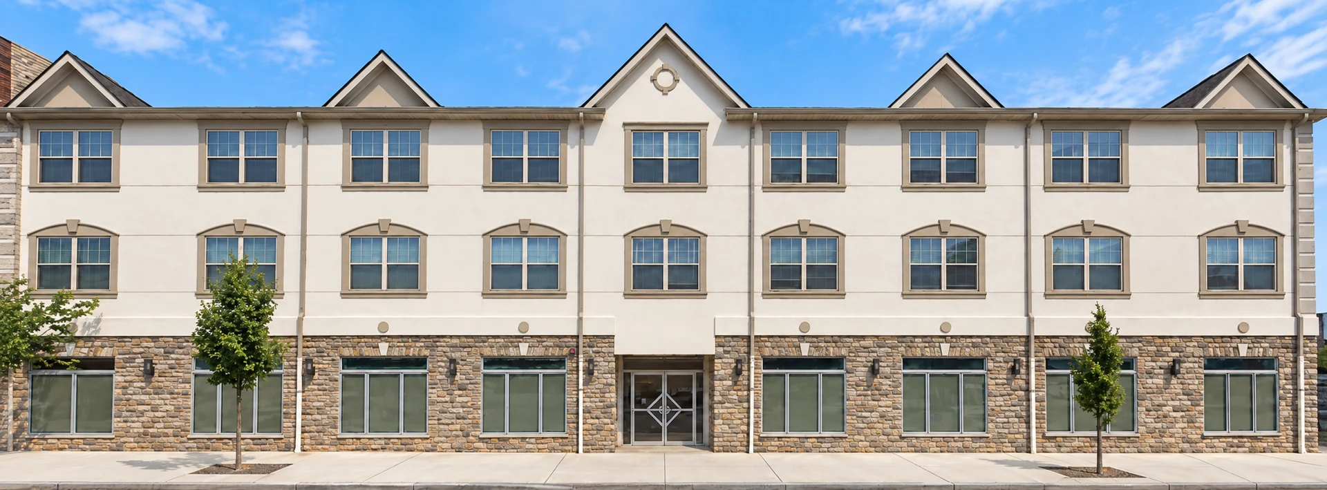 Rahway: Three-story facade with gabled roof accents, stone-clad ground floor and central entrance