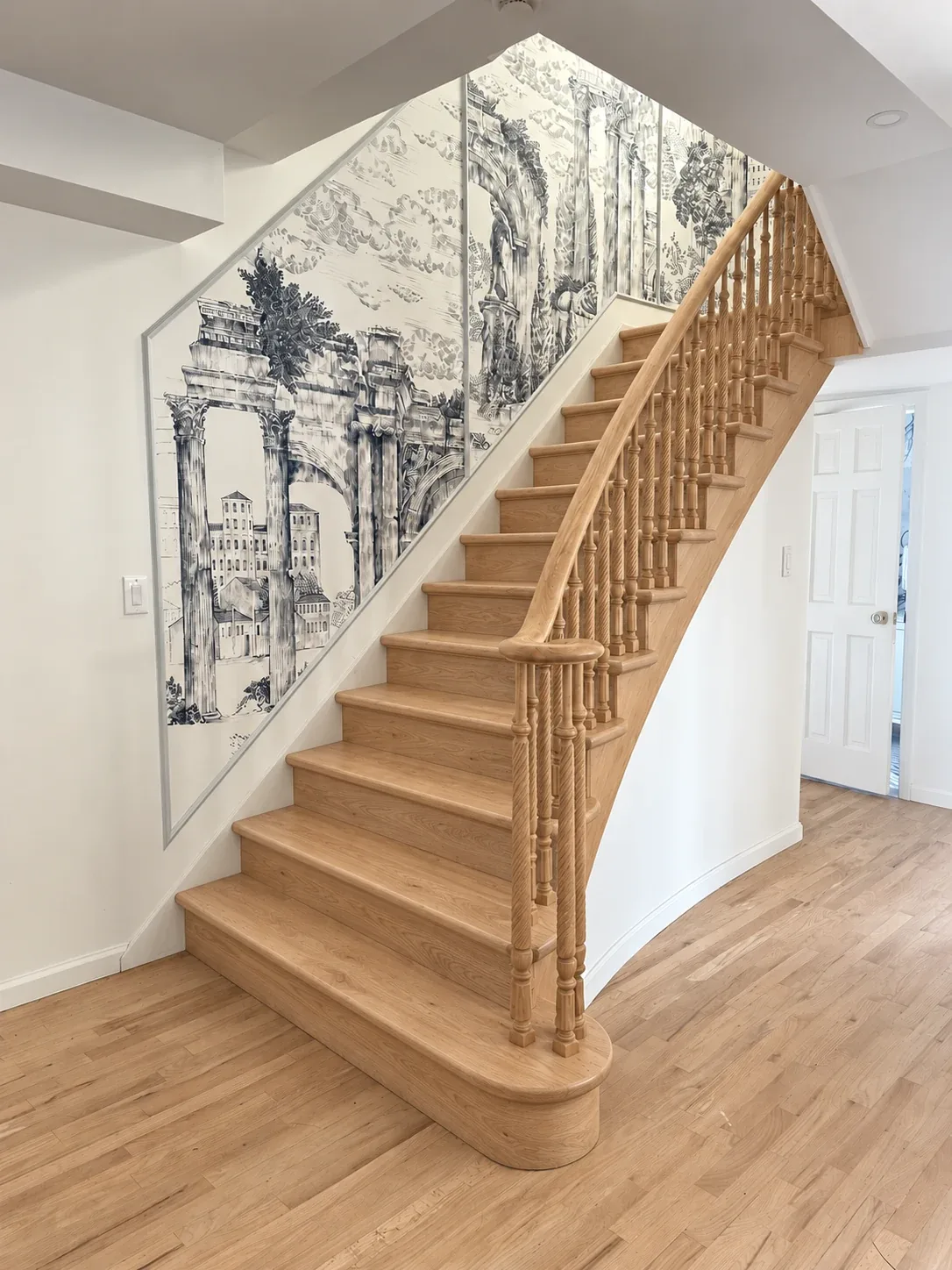 Residential Interiors: Wood staircase with turned balusters and a framed monochrome wall mural