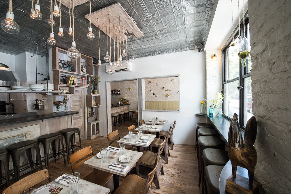 Root & Bone: Dining area with exposed-bulb pendants, decorative ceiling tiles and window-counter seating