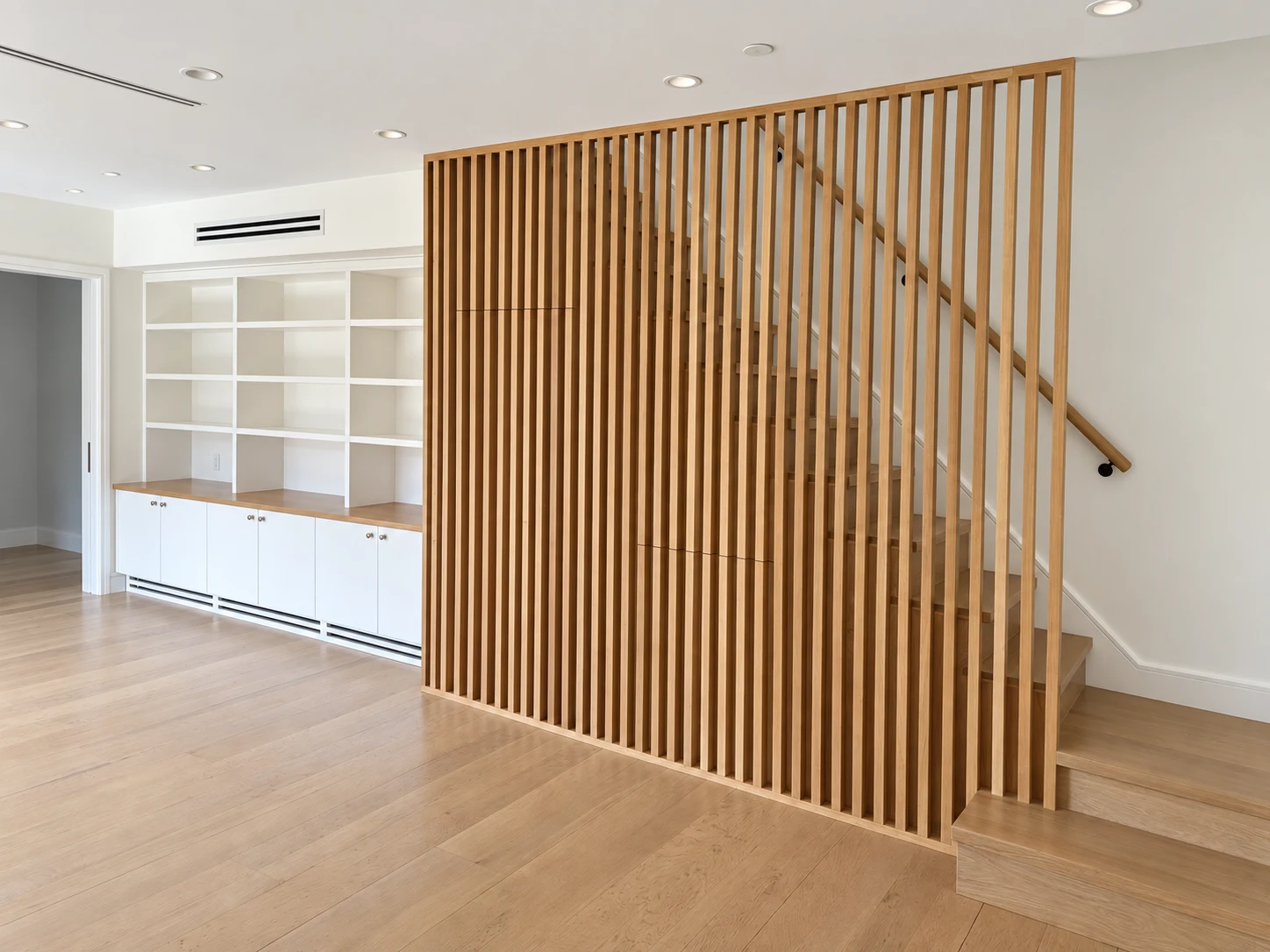 Thump: Wood-slat stair screen beside white built-in shelving and wood flooring