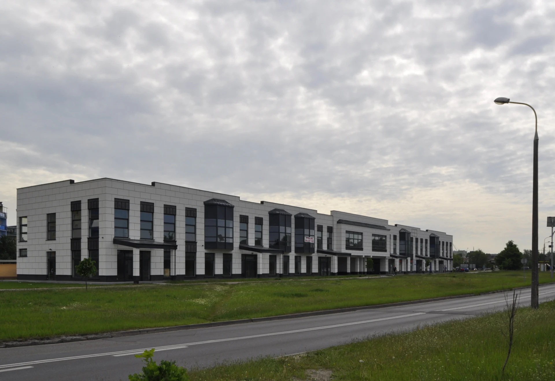 Zale Center: Long two-story building with pale cladding, dark windows and projecting entrance canopies